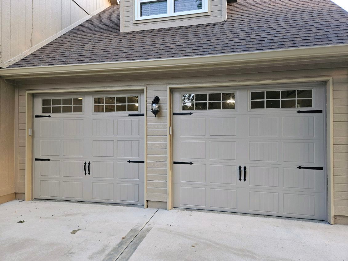 There are two garage doors on the side of a house.