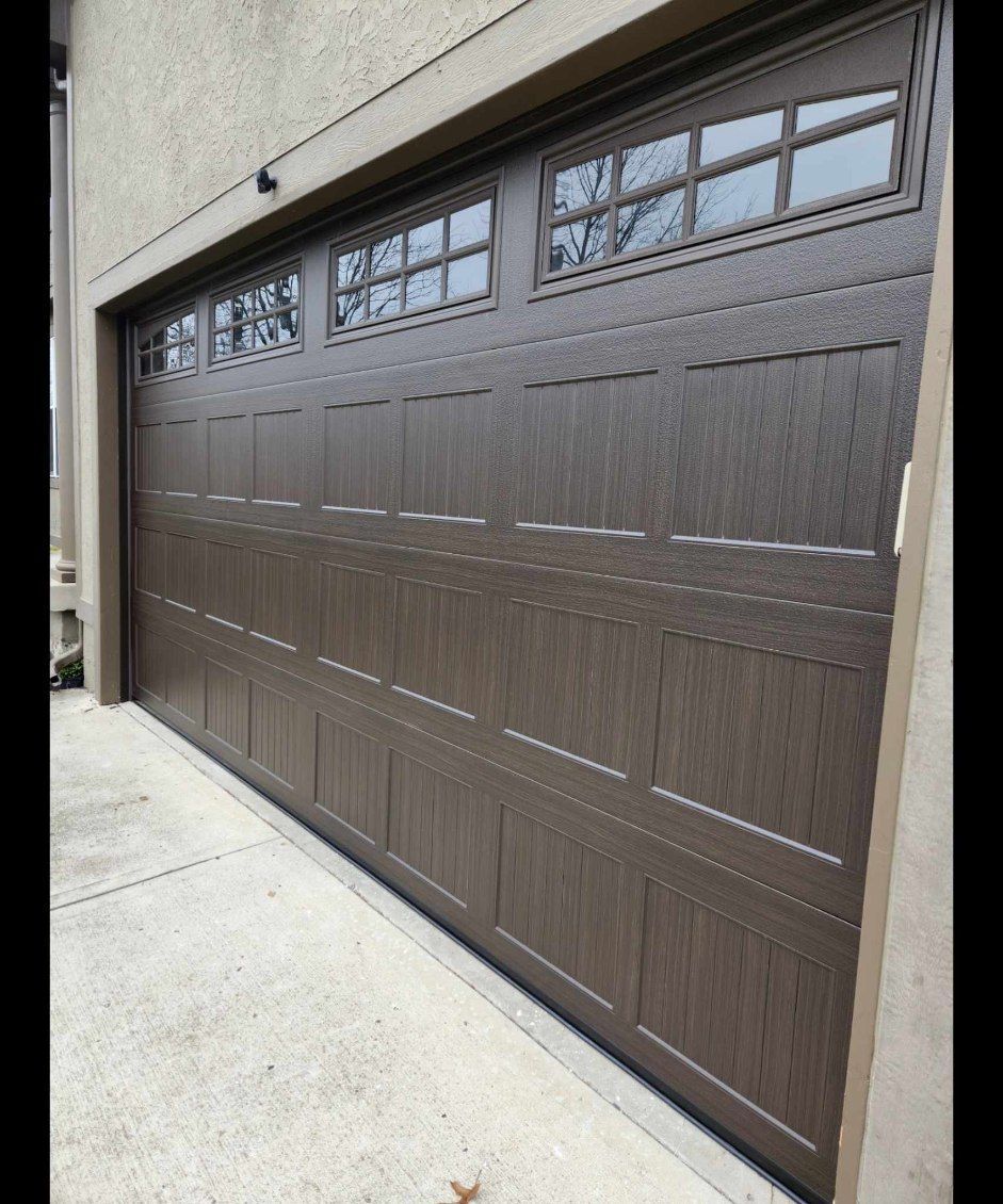 A brown garage door with a lot of windows on a house.