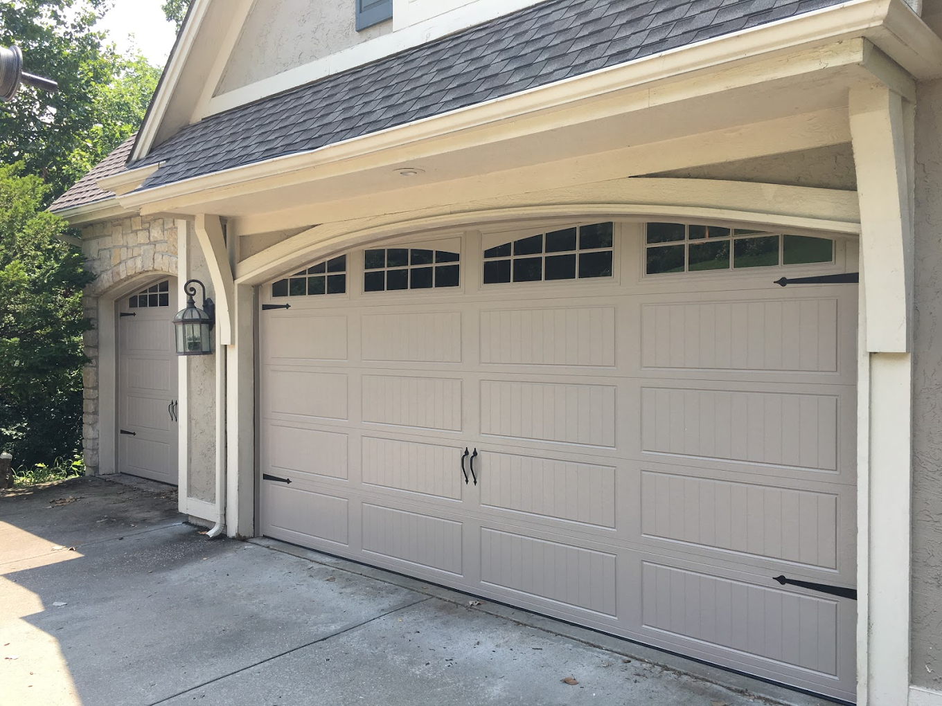 There are two garage doors on the side of a house.