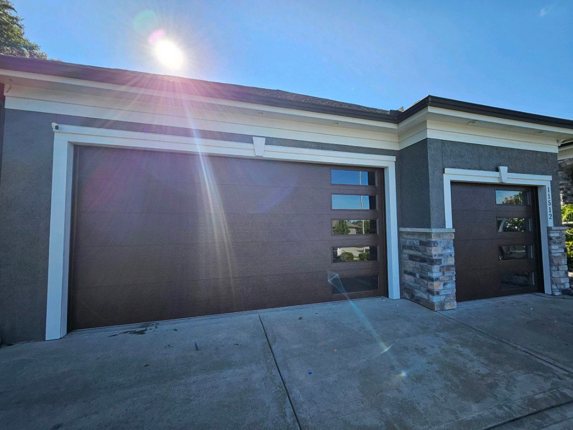 There are two garage doors on the side of a house.