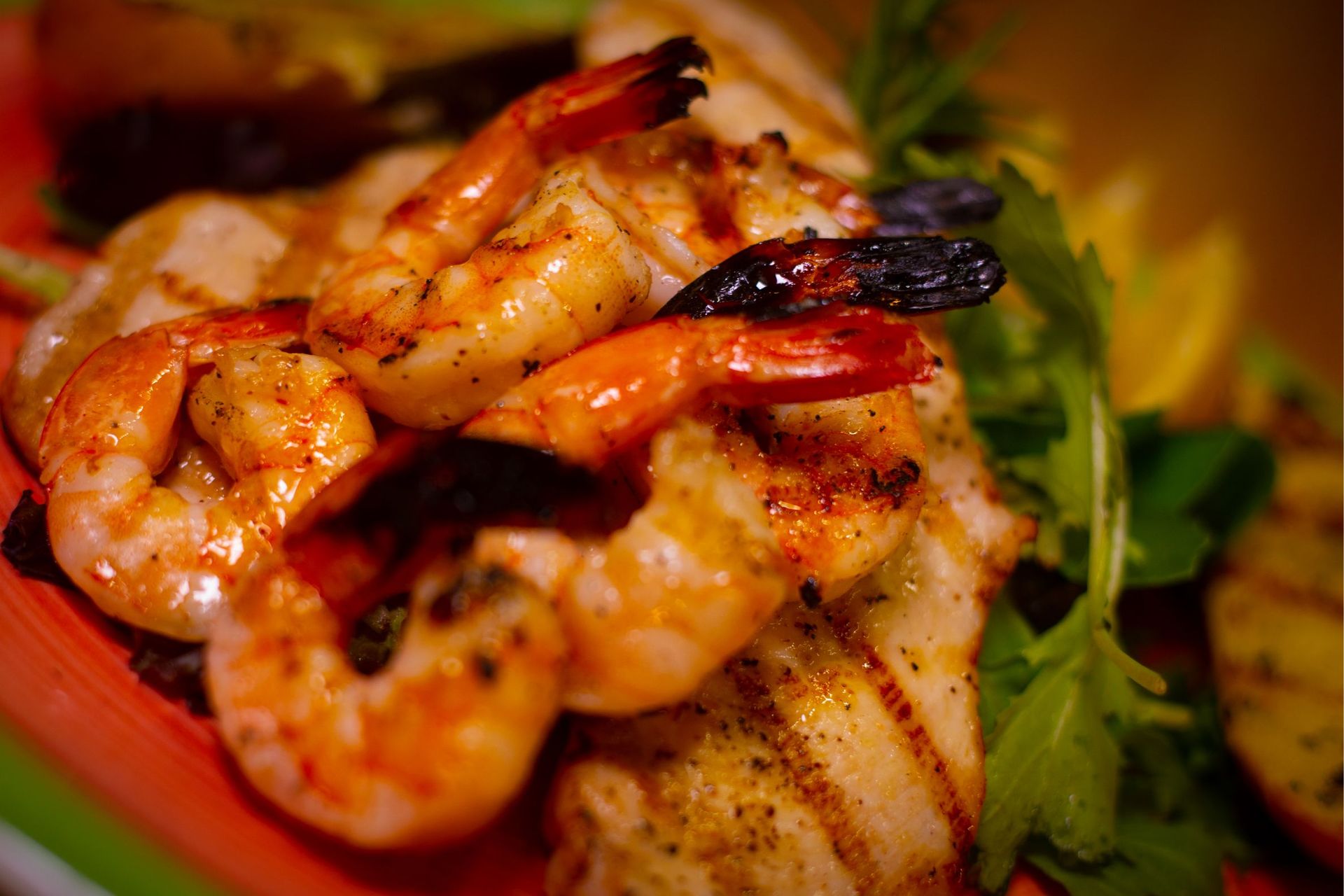A close up of a plate of shrimp and chicken on a table.
