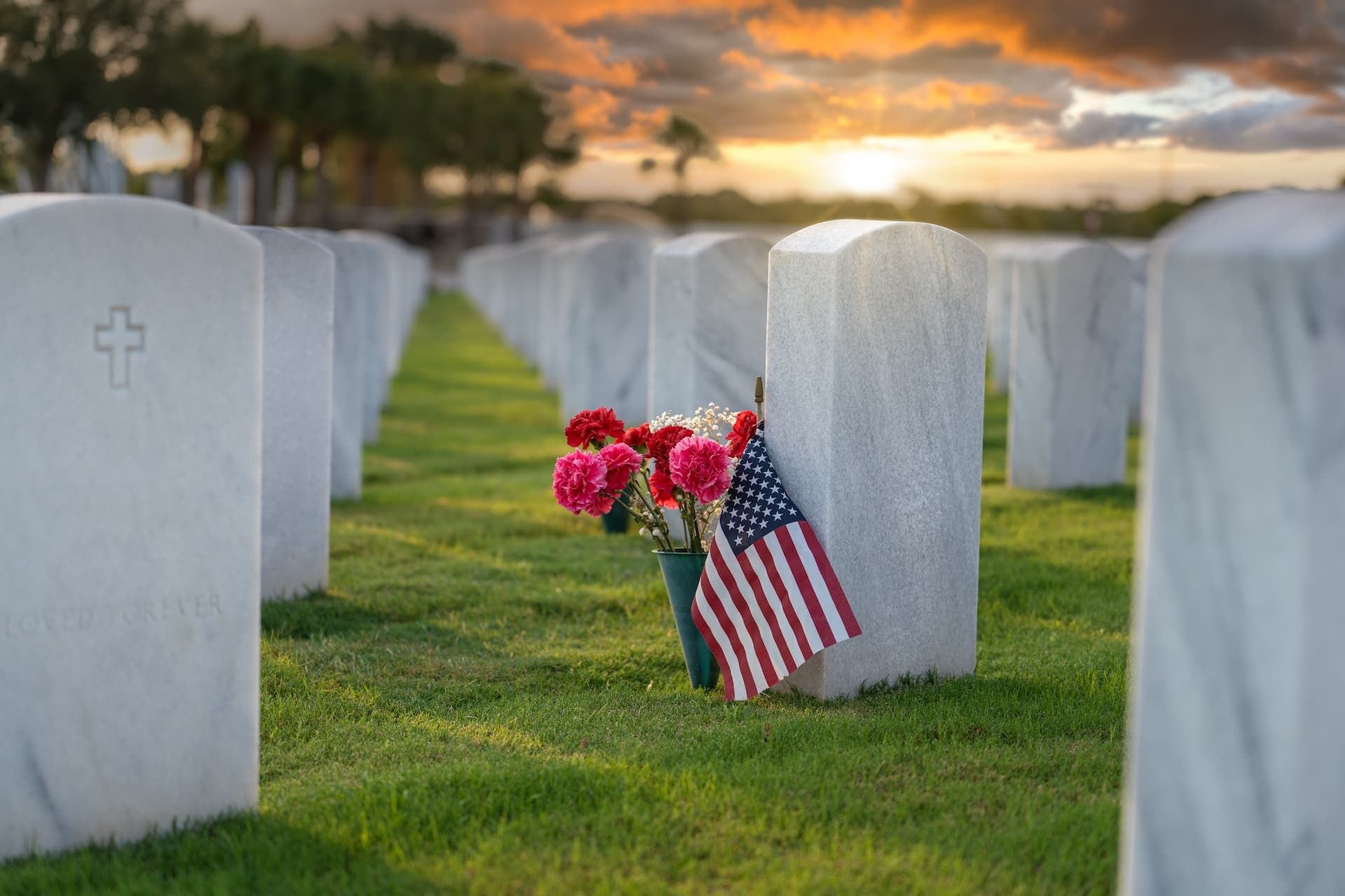 A man in a military uniform is holding an American flag in his hands.