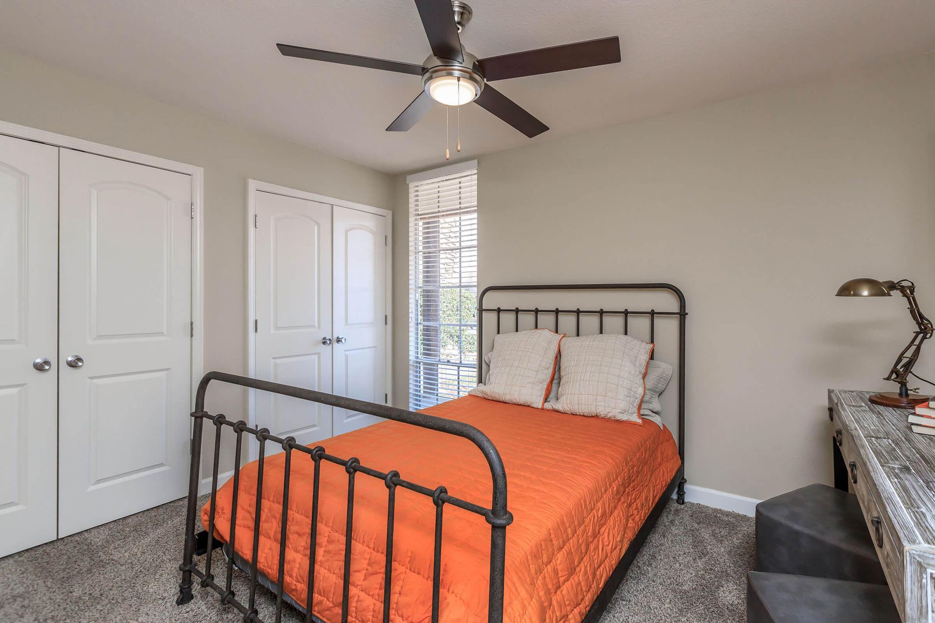 A bedroom with a bed and a ceiling fan at Overbrook Apartments.