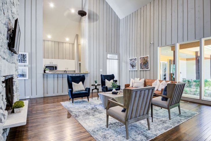 Poolside view with lounge chairs, blue pool, and a building.