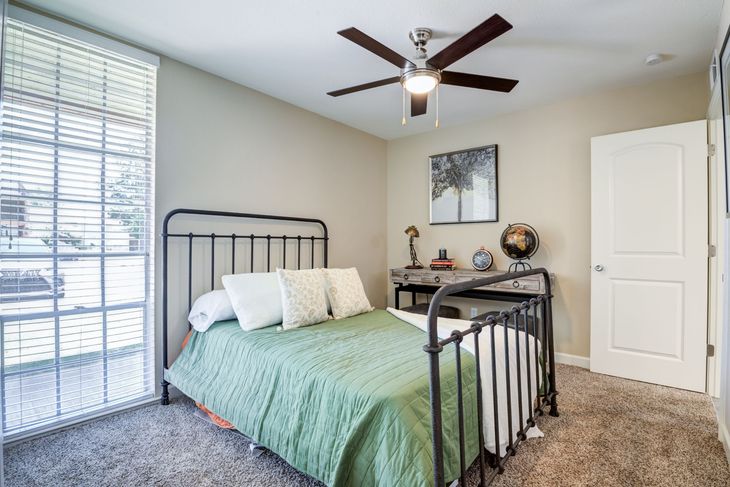 Living room: floral armchair, dining table, ceiling fan, and doorway.