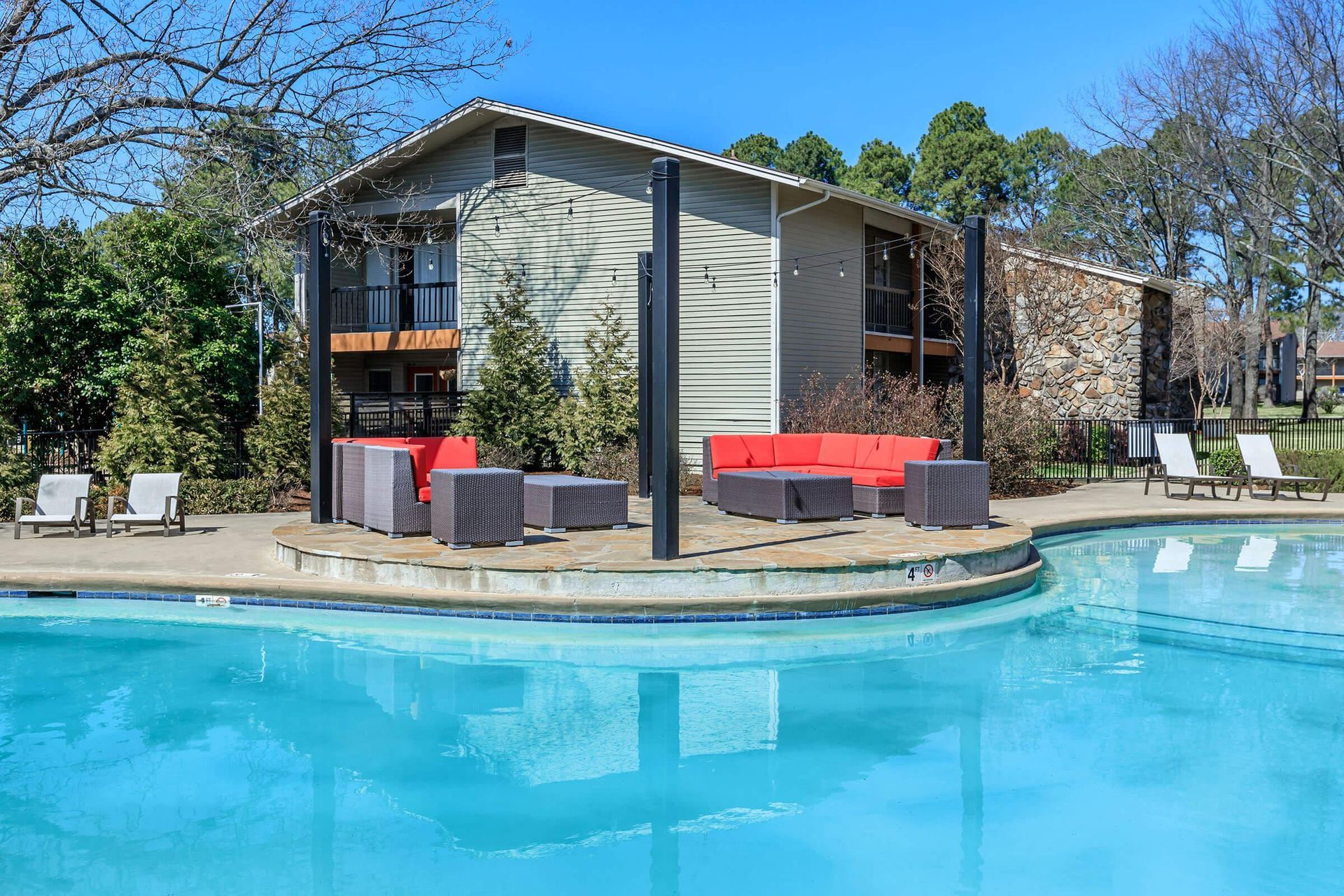There is a large swimming pool in front of a building at Overbrook Apartments.