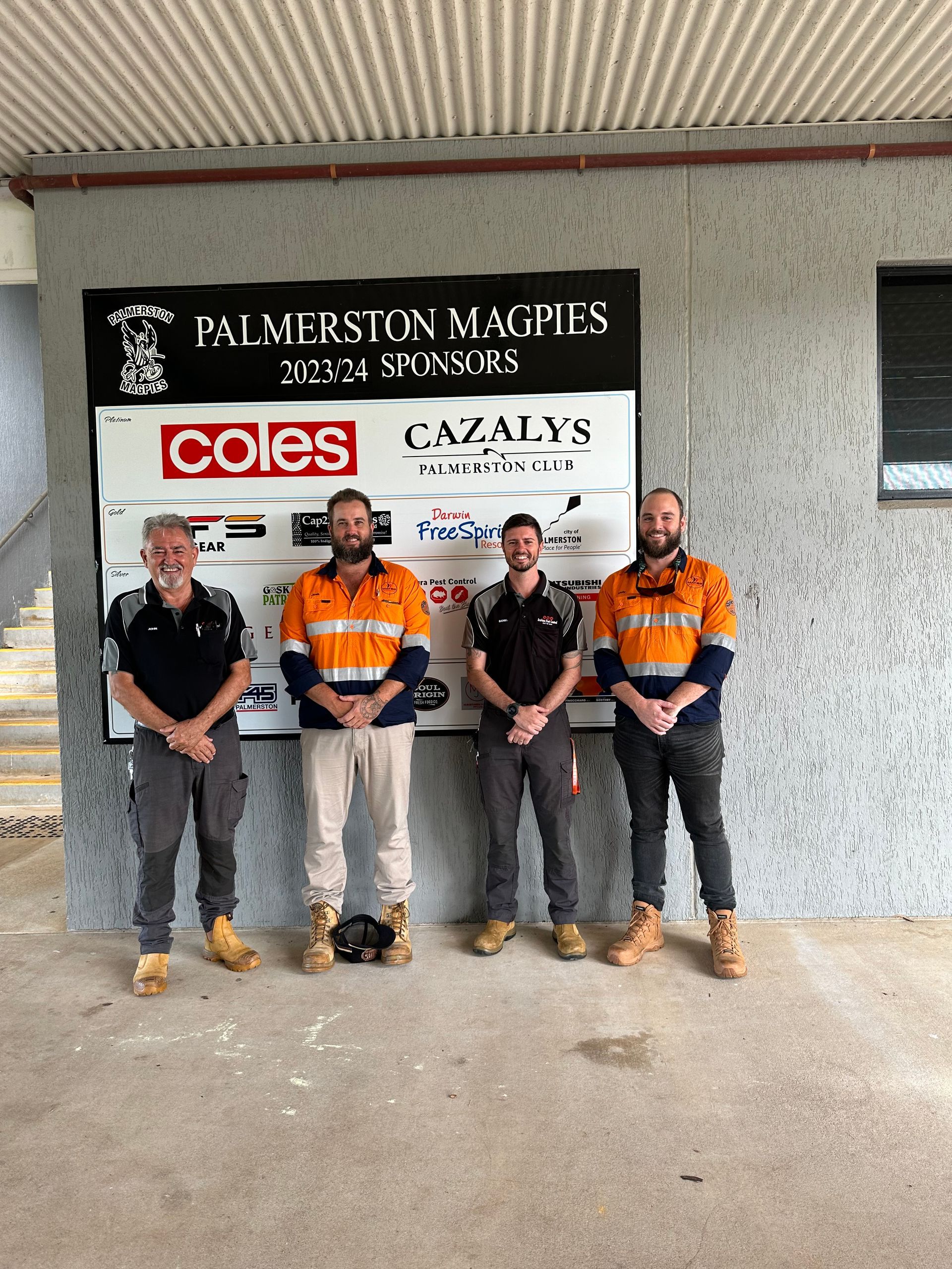 A group of men are standing in front of a sign that says coles.