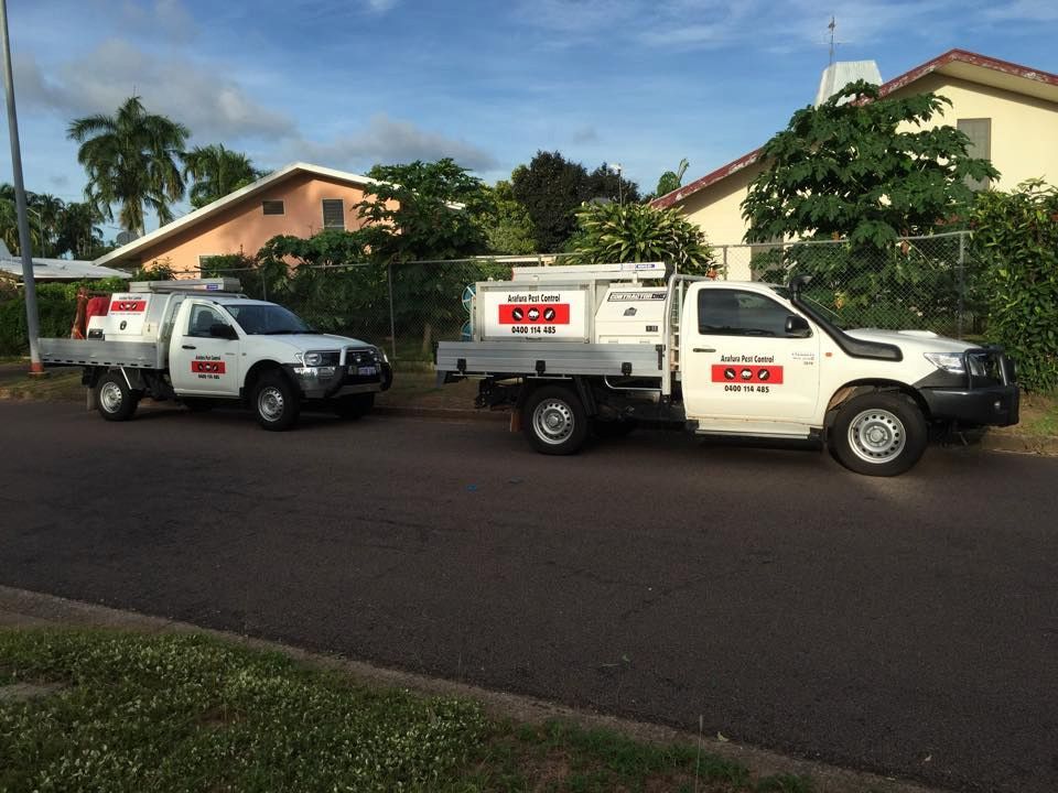 Two White Service Trucks Parked on a Street in Front of Houses — Arafura Pest Control Darwin In Yarrawonga, NT