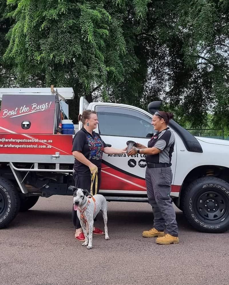 Two Women Shake Hands Next to a White Work Truck — Arafura Pest Control Darwin In Yarrawonga, NT