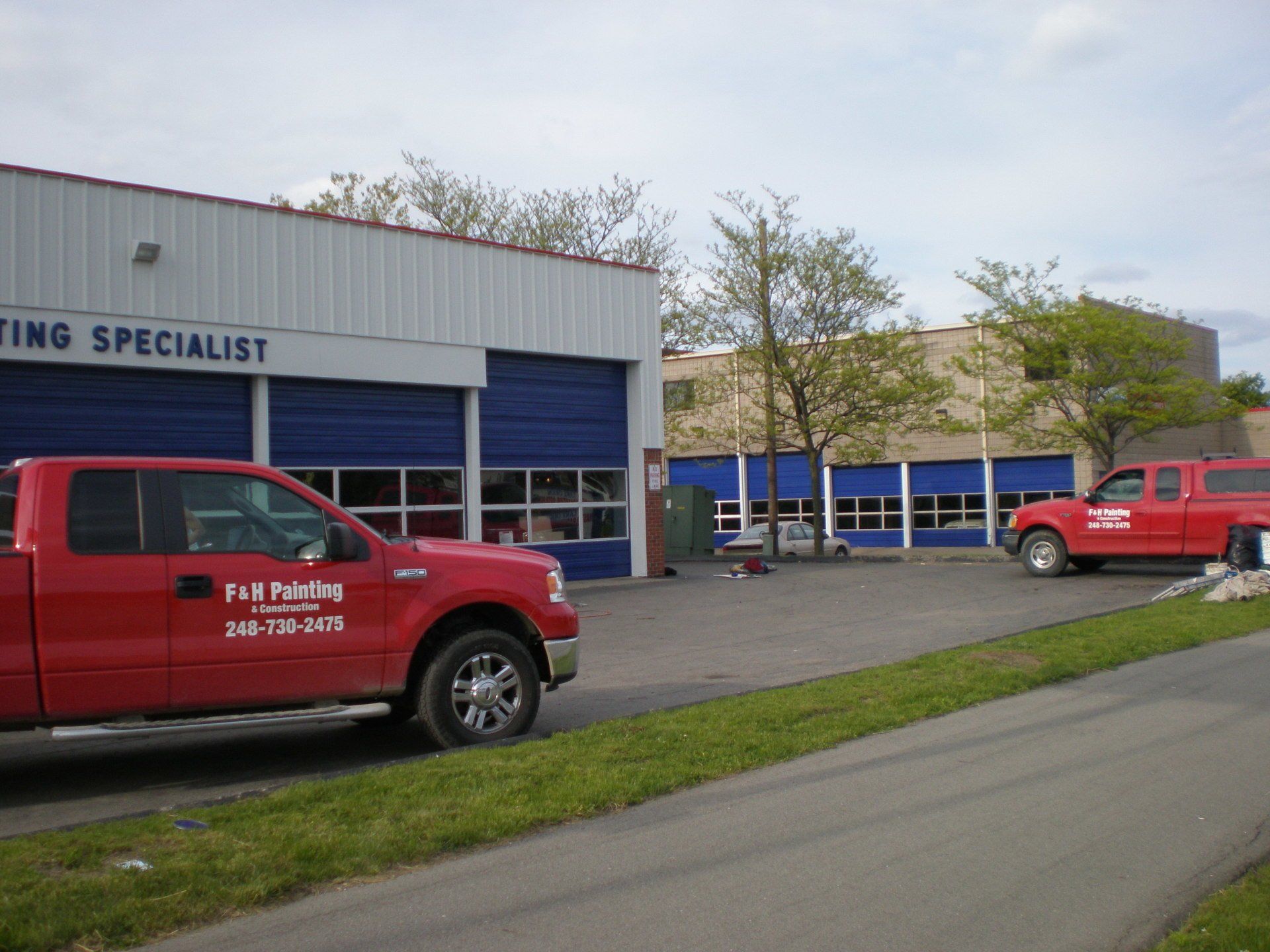 F&H Painting's red company vehicles in front of their office