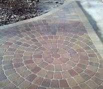 A patio with a fire pit and a potted plant on it.