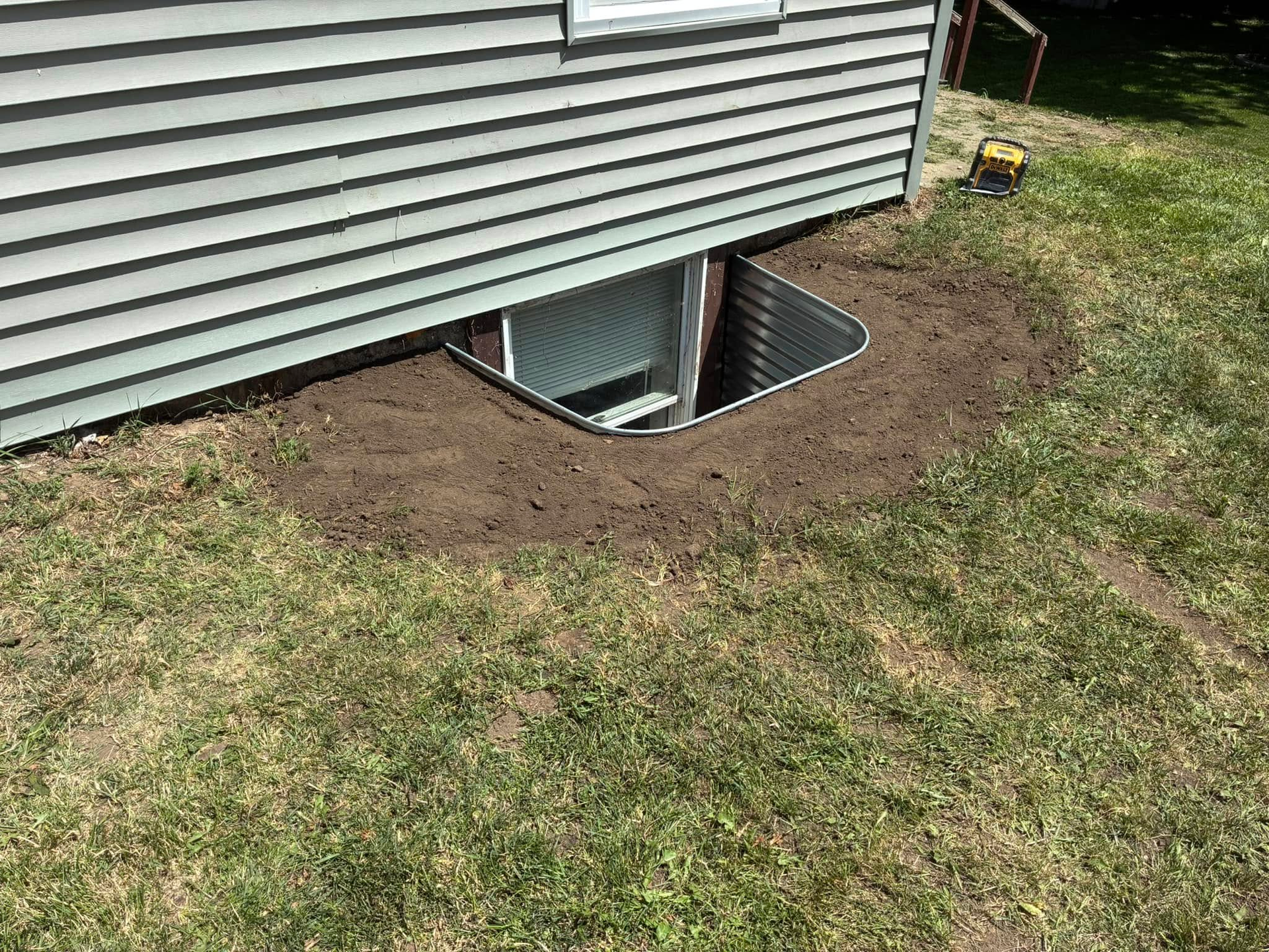 Front of a house with a green lawn and gravel landscaping.