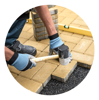 a man is using a rubber mallet to hammer bricks on a sidewalk