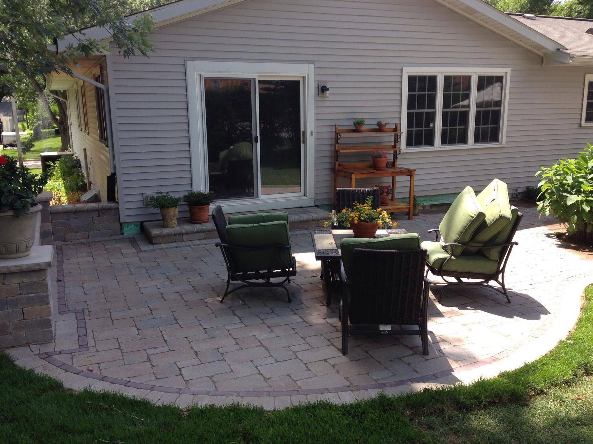 A patio with chairs and a table in front of a house