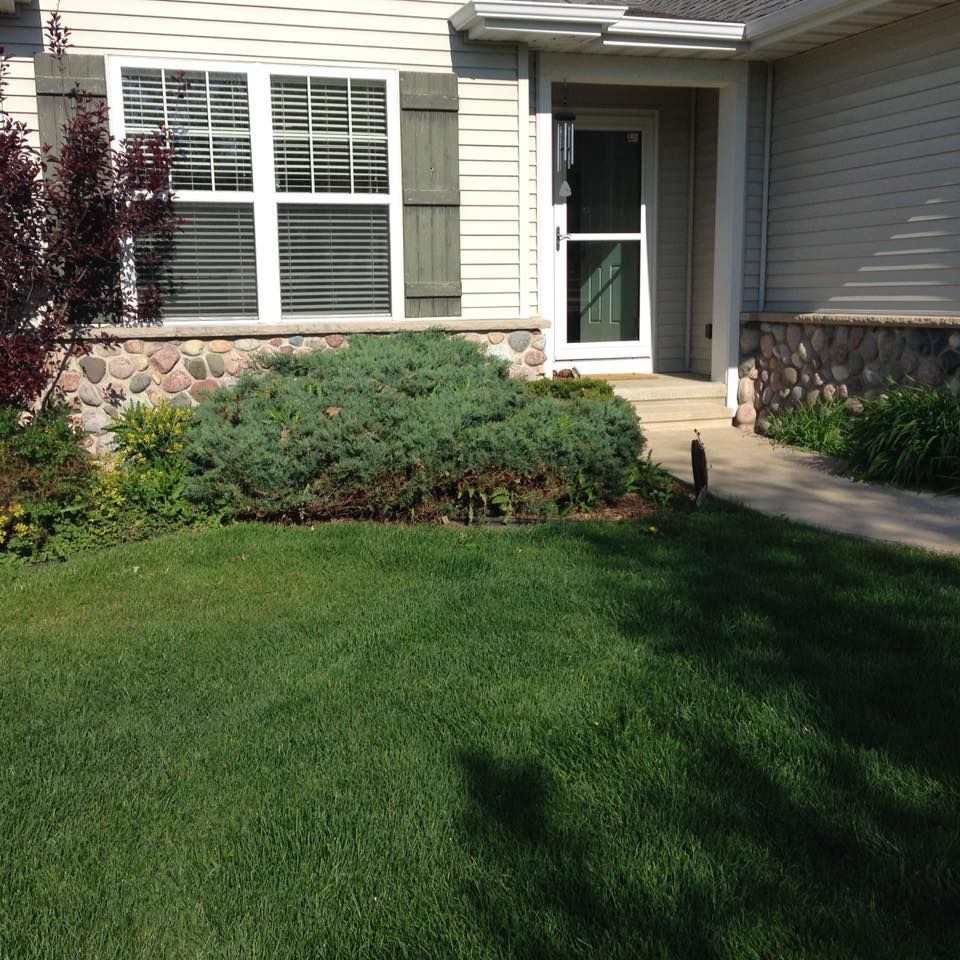 A house with a lush green lawn in front of it