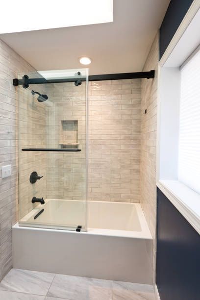A contemporary modern bathroom design. featuring a custom frameless shower enclosure.