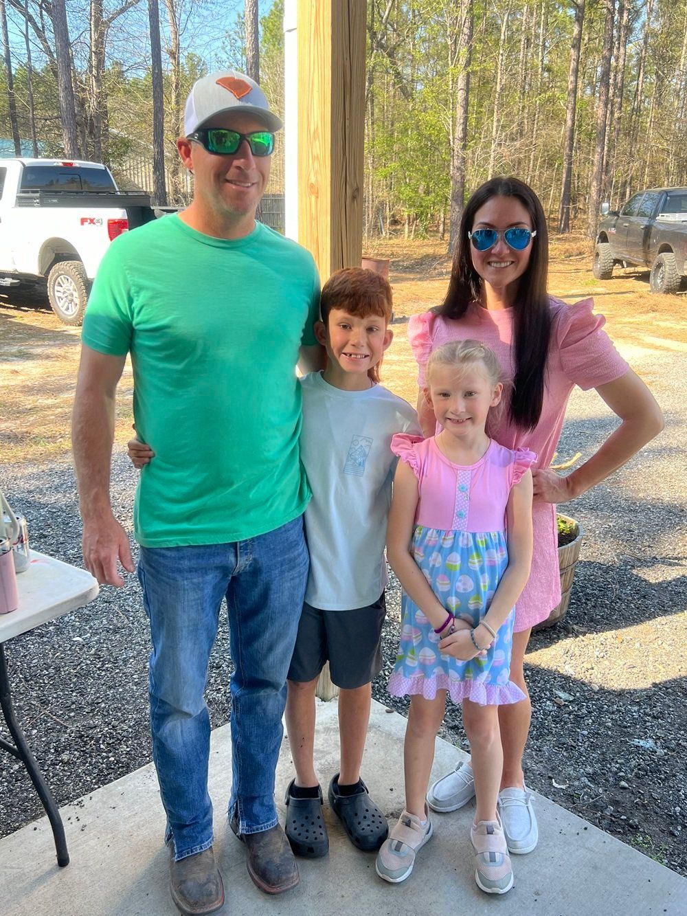 A man , woman , and two children are posing for a picture.