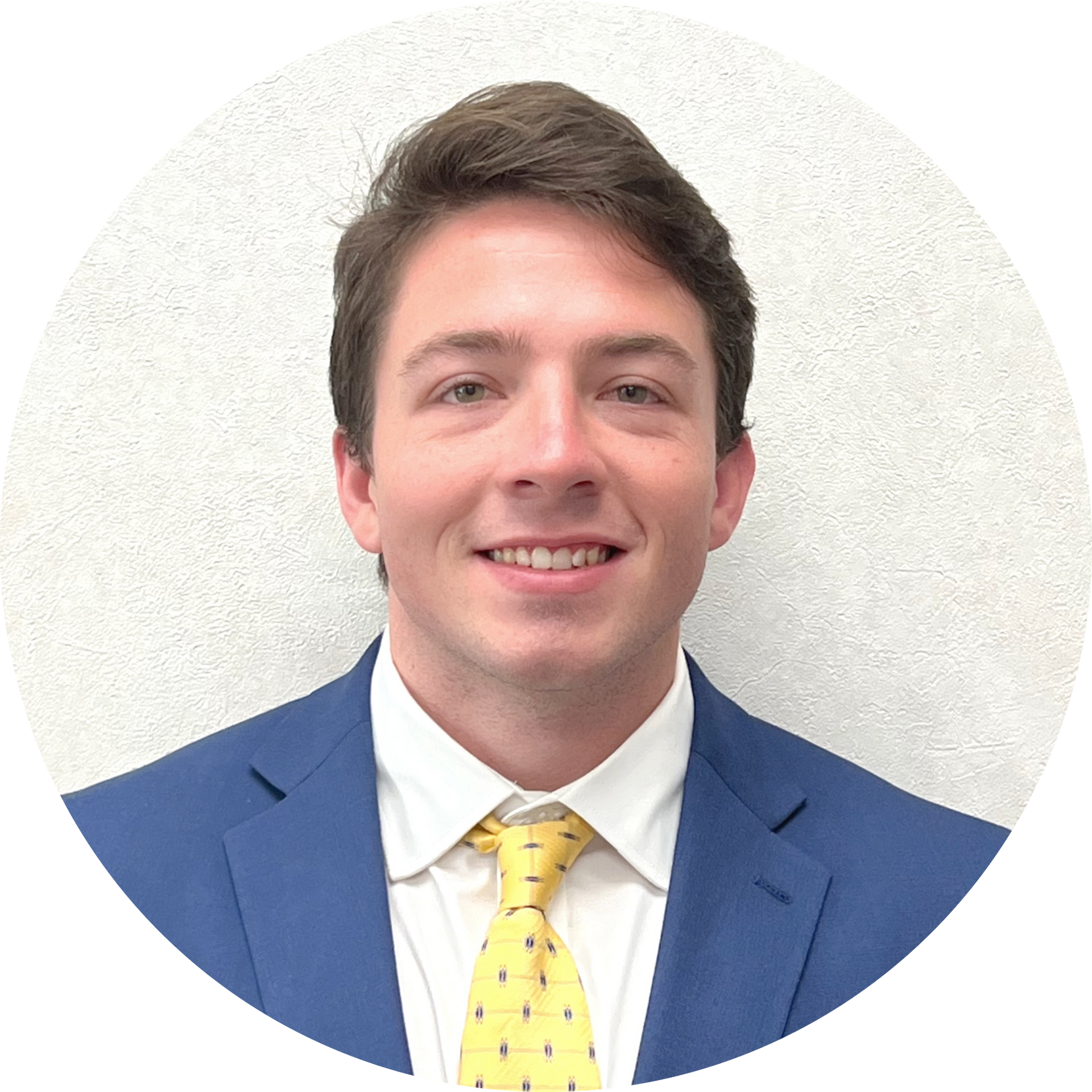 A man in a blue suit and yellow tie smiles for the camera