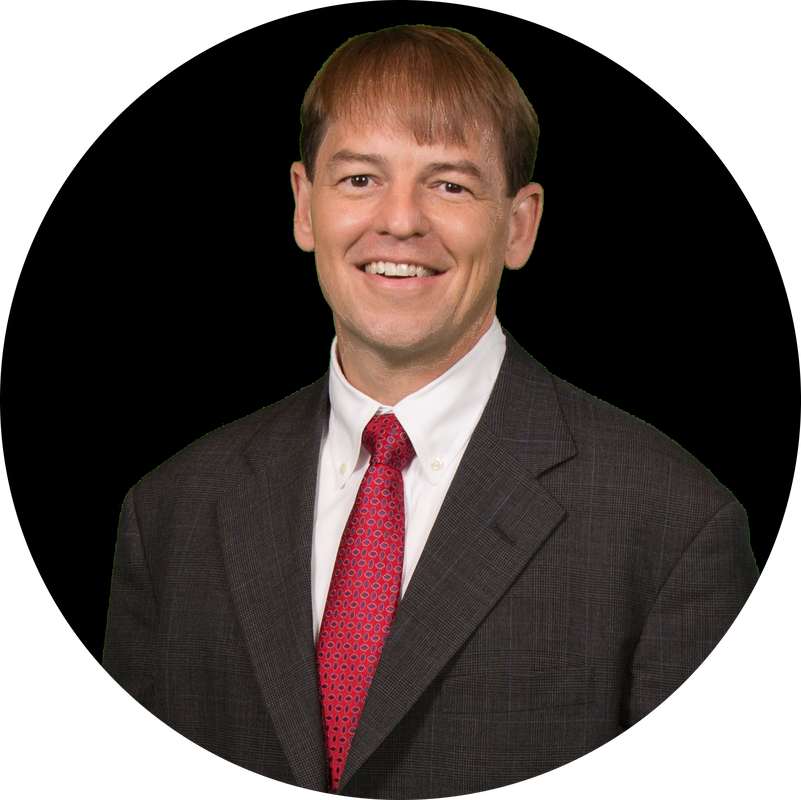 A man in a suit and tie is smiling for the camera