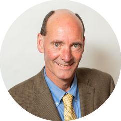 A man in a suit and tie is smiling for the camera