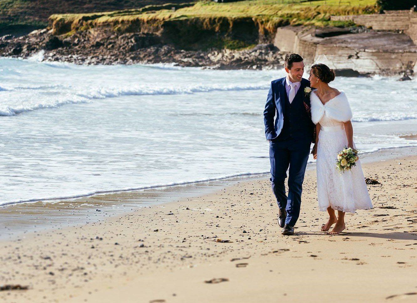 Wedding couple strolling along beach at Rosscarbery 