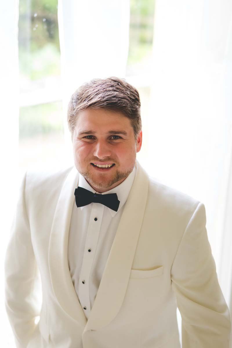 Ballinacurra House groom standing for a portrait in white tux