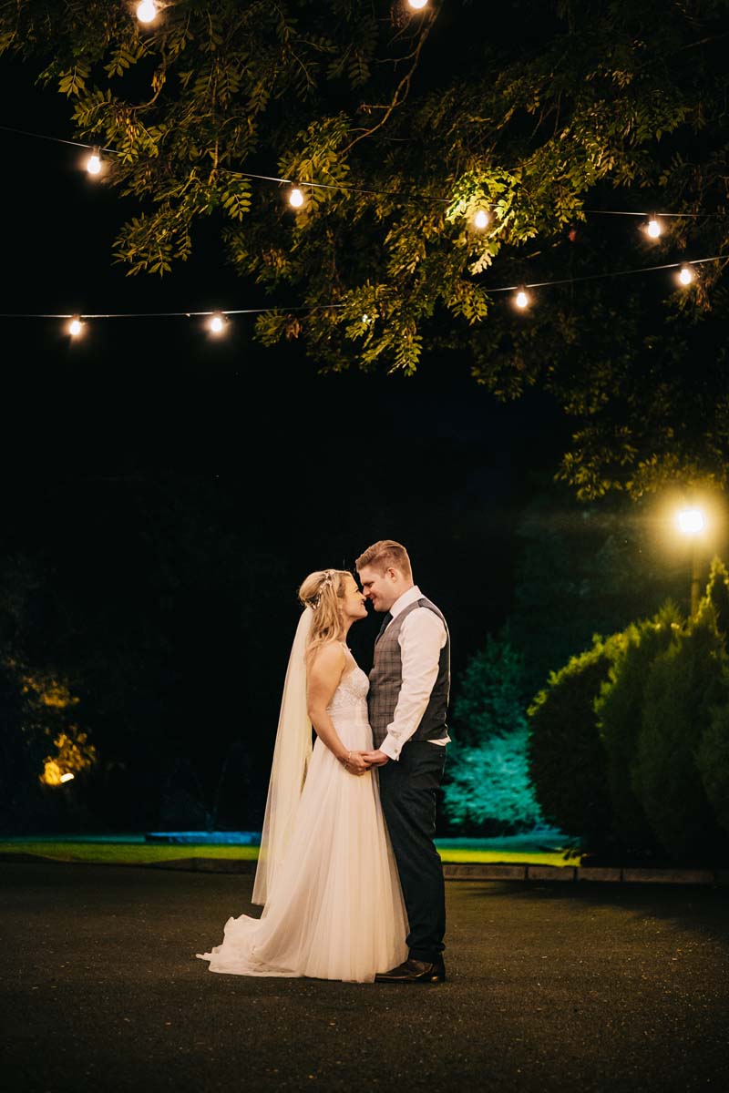 Fitzgeralds Vienna Woods wedding photos - bride and groom standing with fairy lights at night