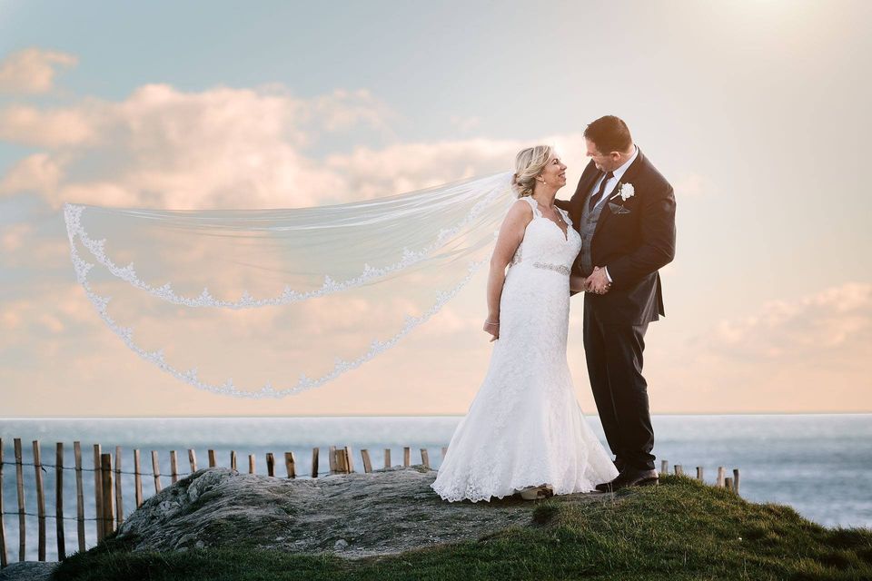 Inchydoney Island Lodge & Spa wedding photo of couple standing together with ocean behind sunset