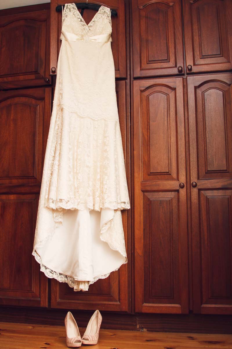 wedding dress hanging from dar wood wardrobe