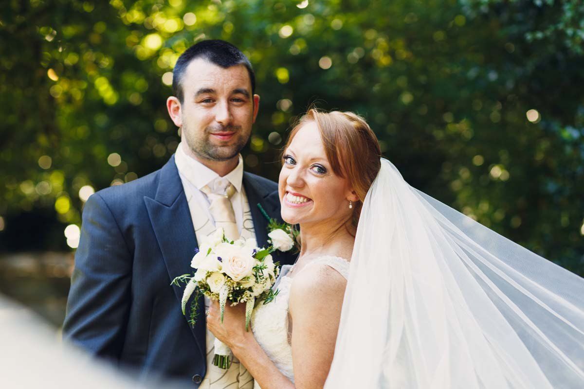 wedding couple with veil standing in tree driveway at Barnabrow House