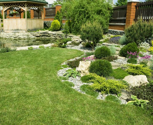 A lush green garden with a gazebo in the background.