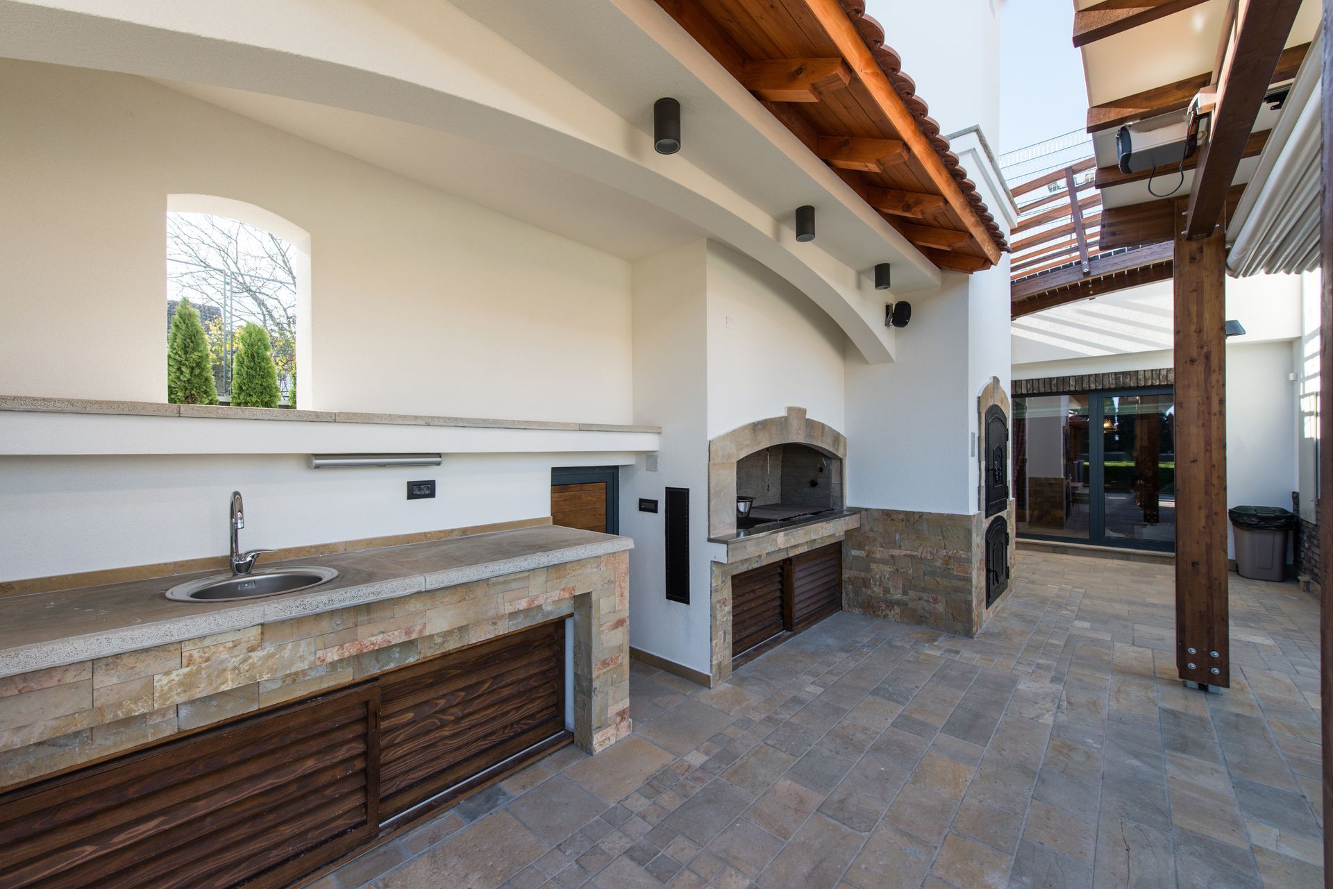 A large outdoor kitchen with a sink and a grill.