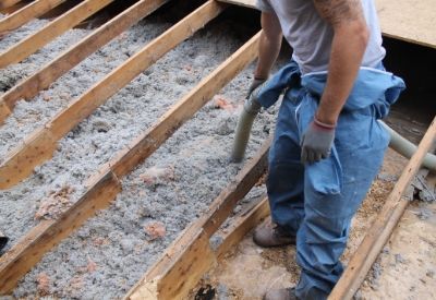 An image of a GBCI expert removing old insulation from a crawlspace