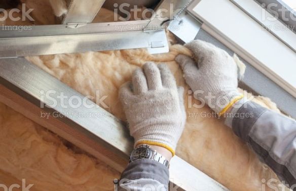 An image of an expert adjusting insulation in the wall