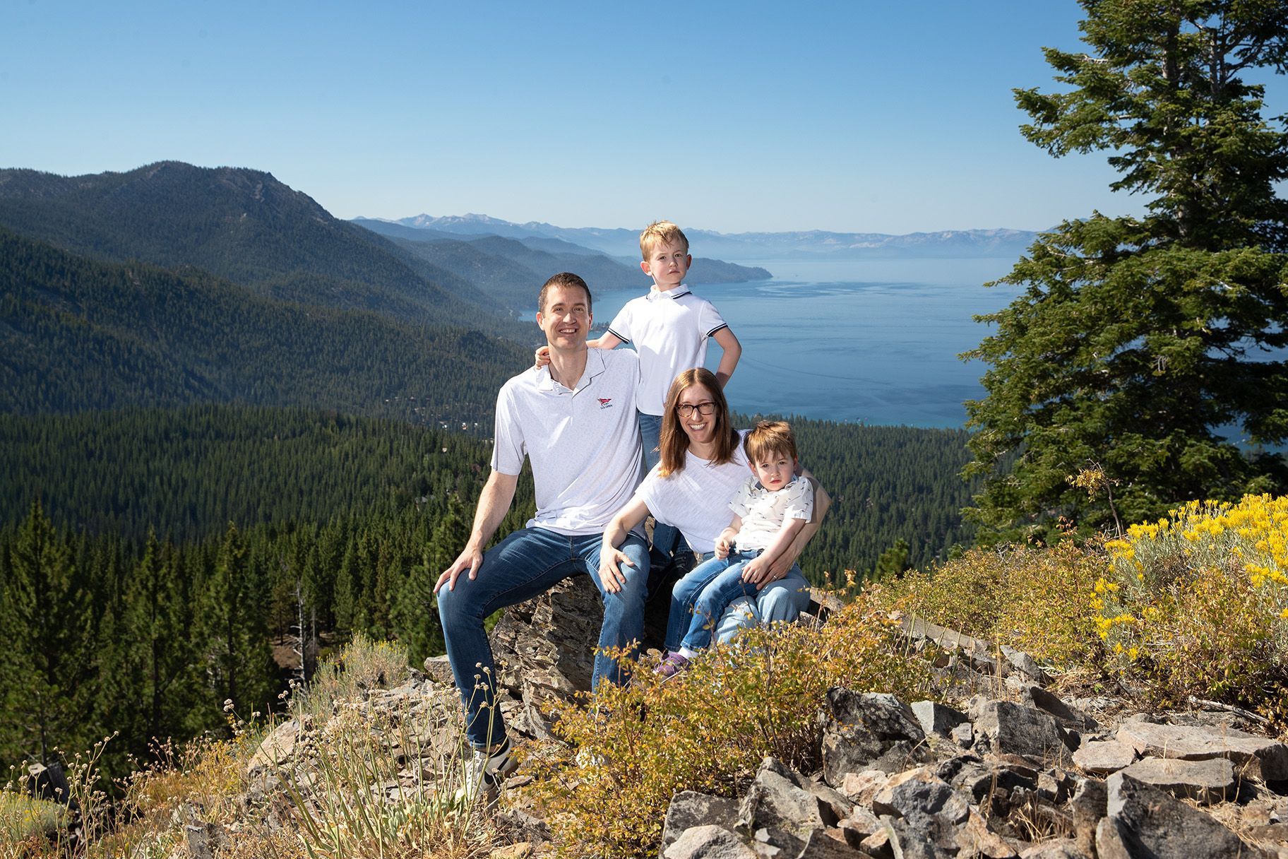 Candid family photo with pine forest and Lake Tahoe in the background
