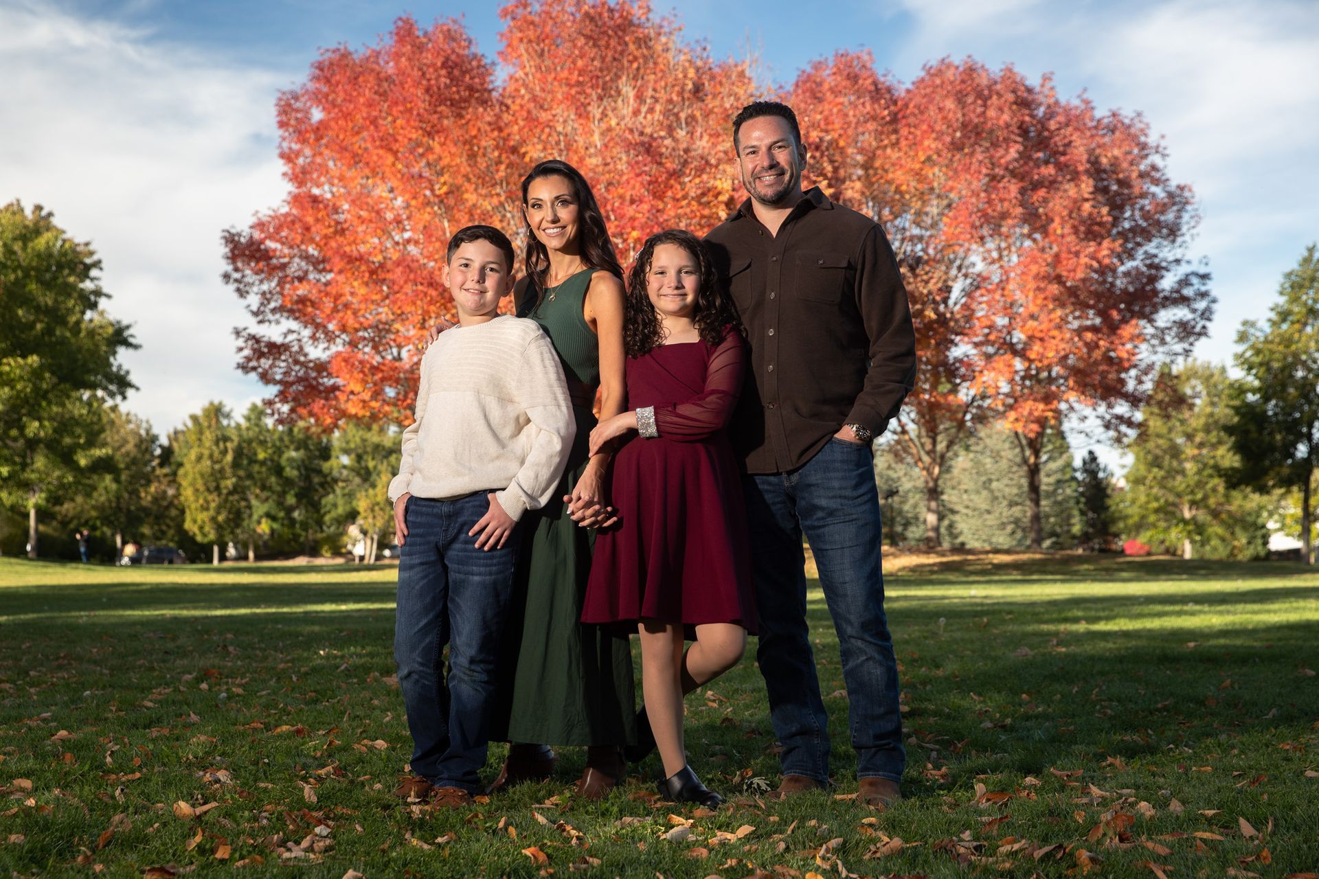 Family group photo framed by glowing aspens during peak fall color season.