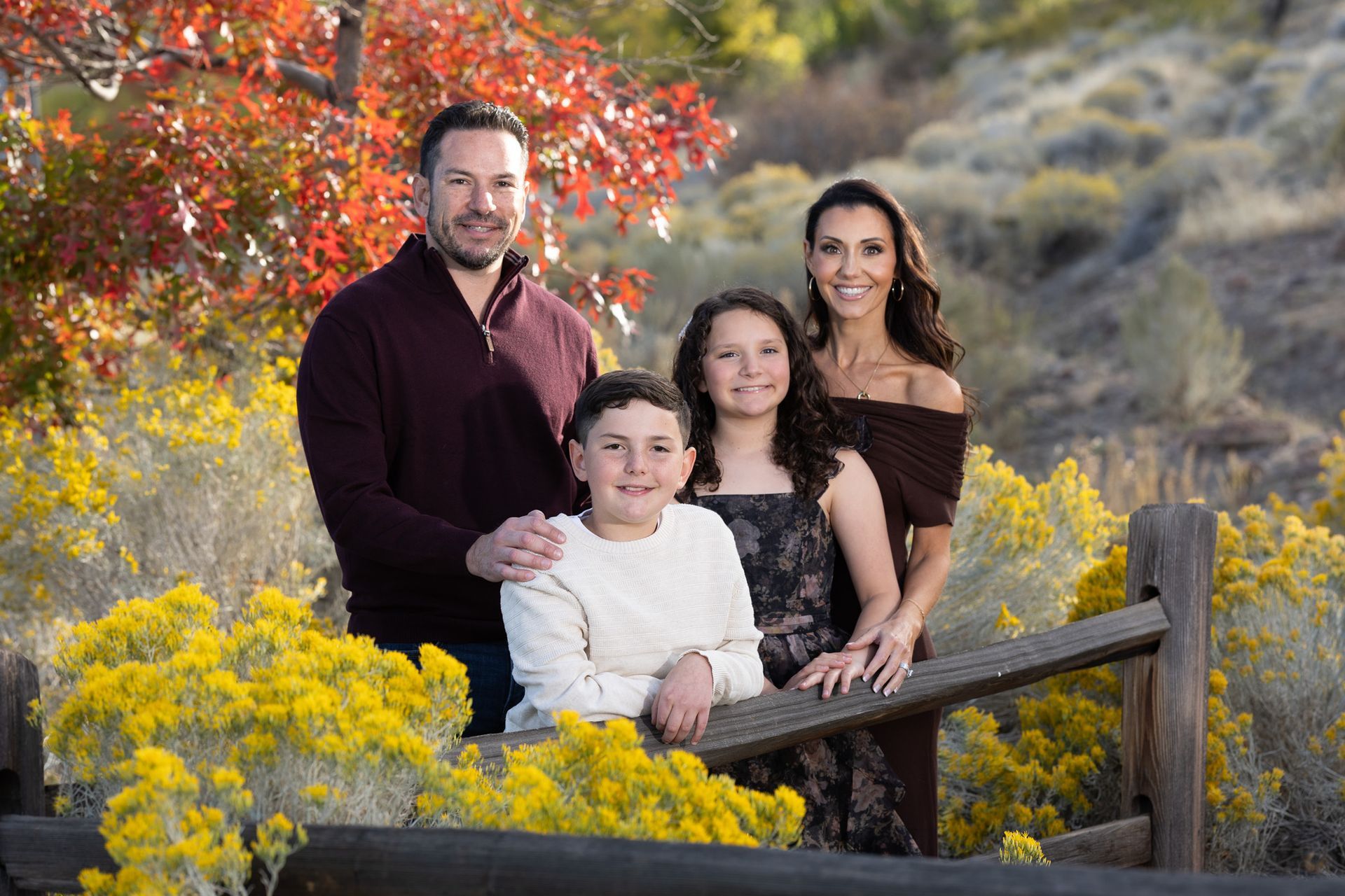 Wide landscape of family standing by Tahoe trees fall sunset.
