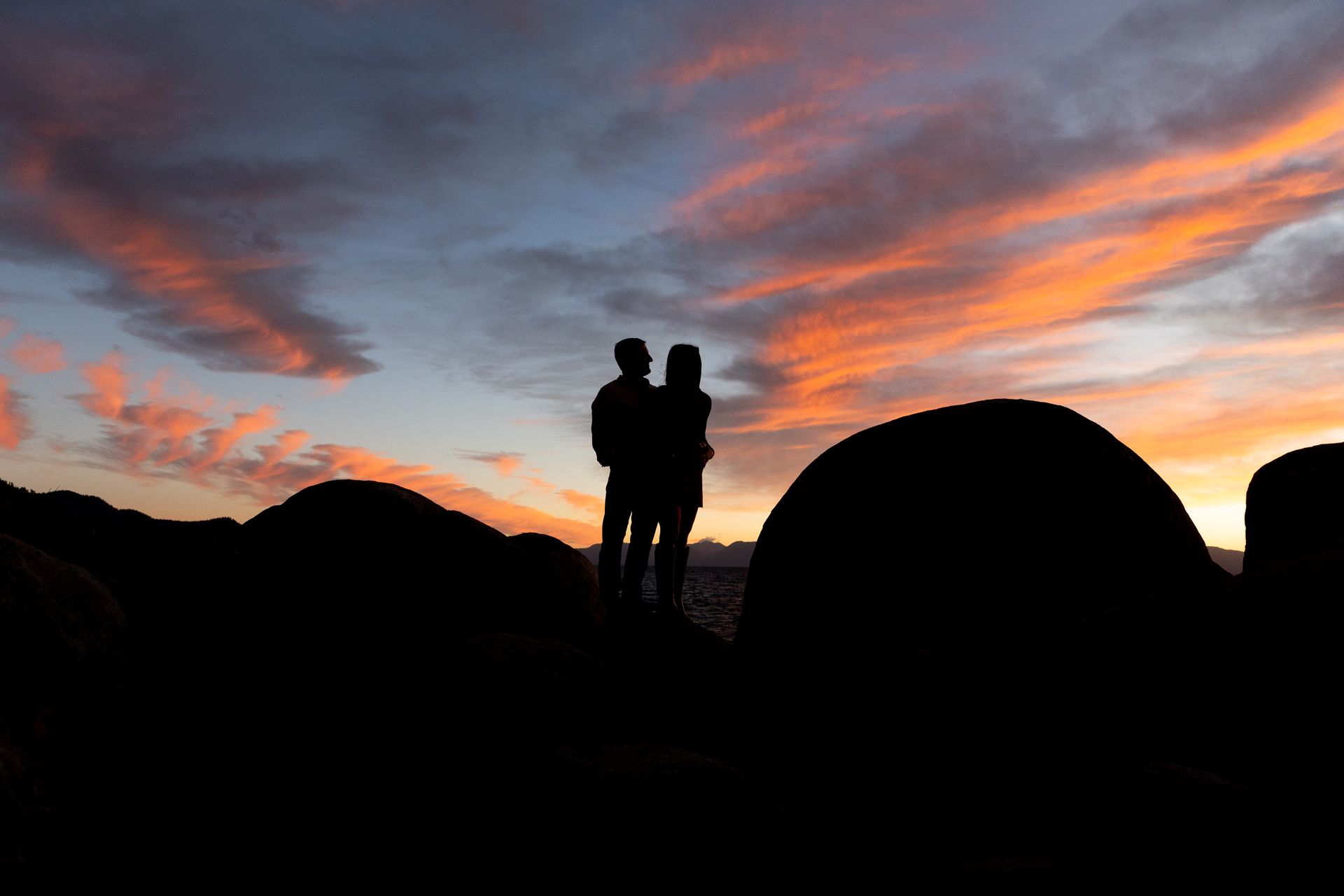 Kids exploring and climbing granite boulders at North Lake Tahoe during a family photo session at sunset.