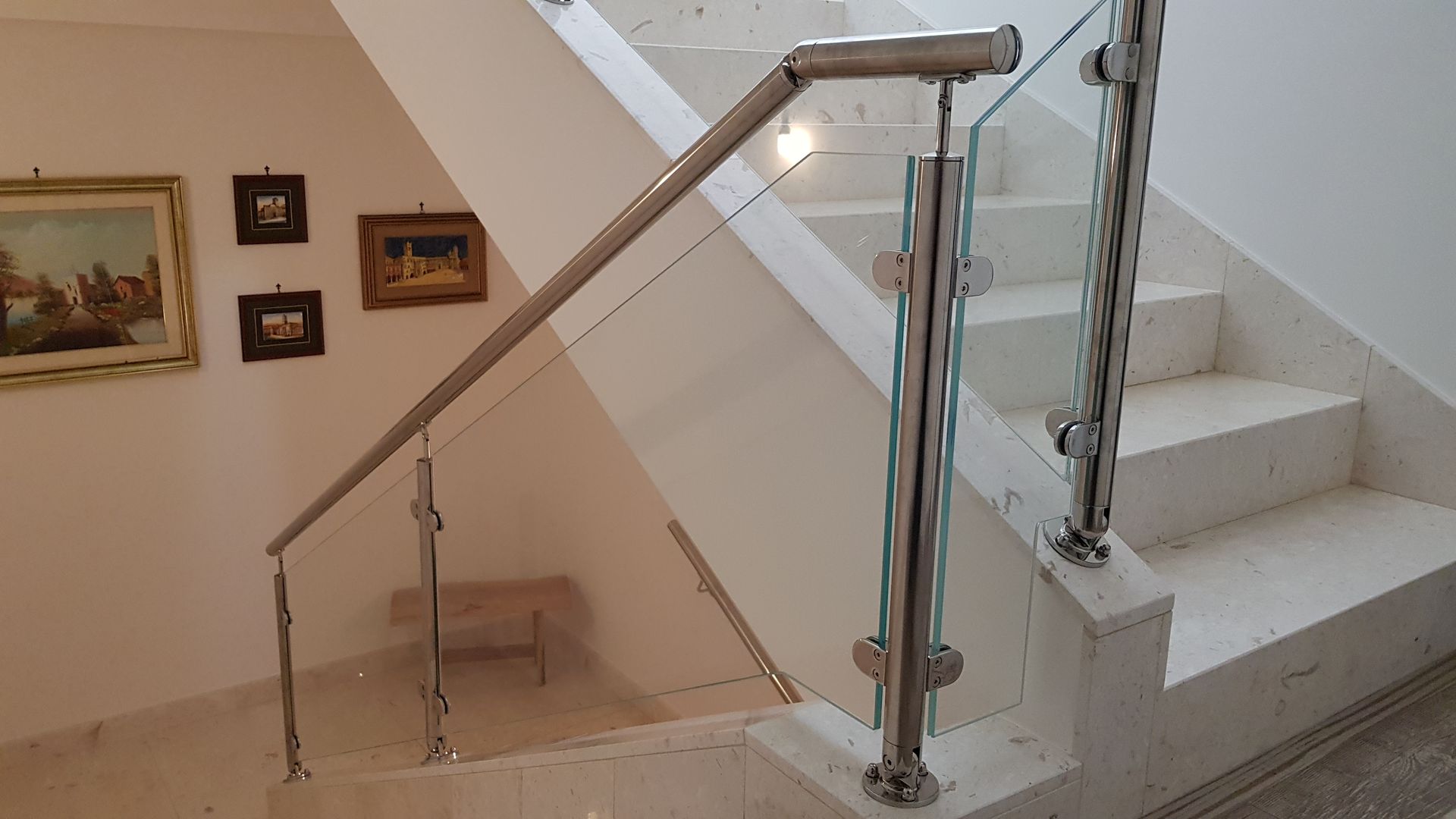 Una scala con ringhiera in acciaio inox e ringhiera in vetro.