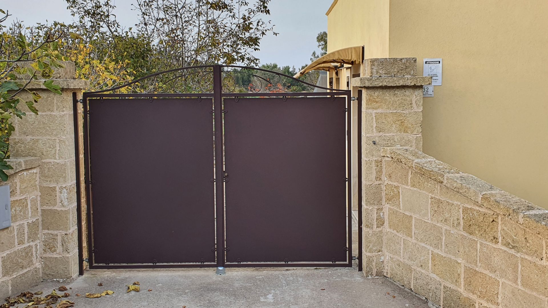 Un cancello marrone è posto di fronte a un muro di mattoni.
