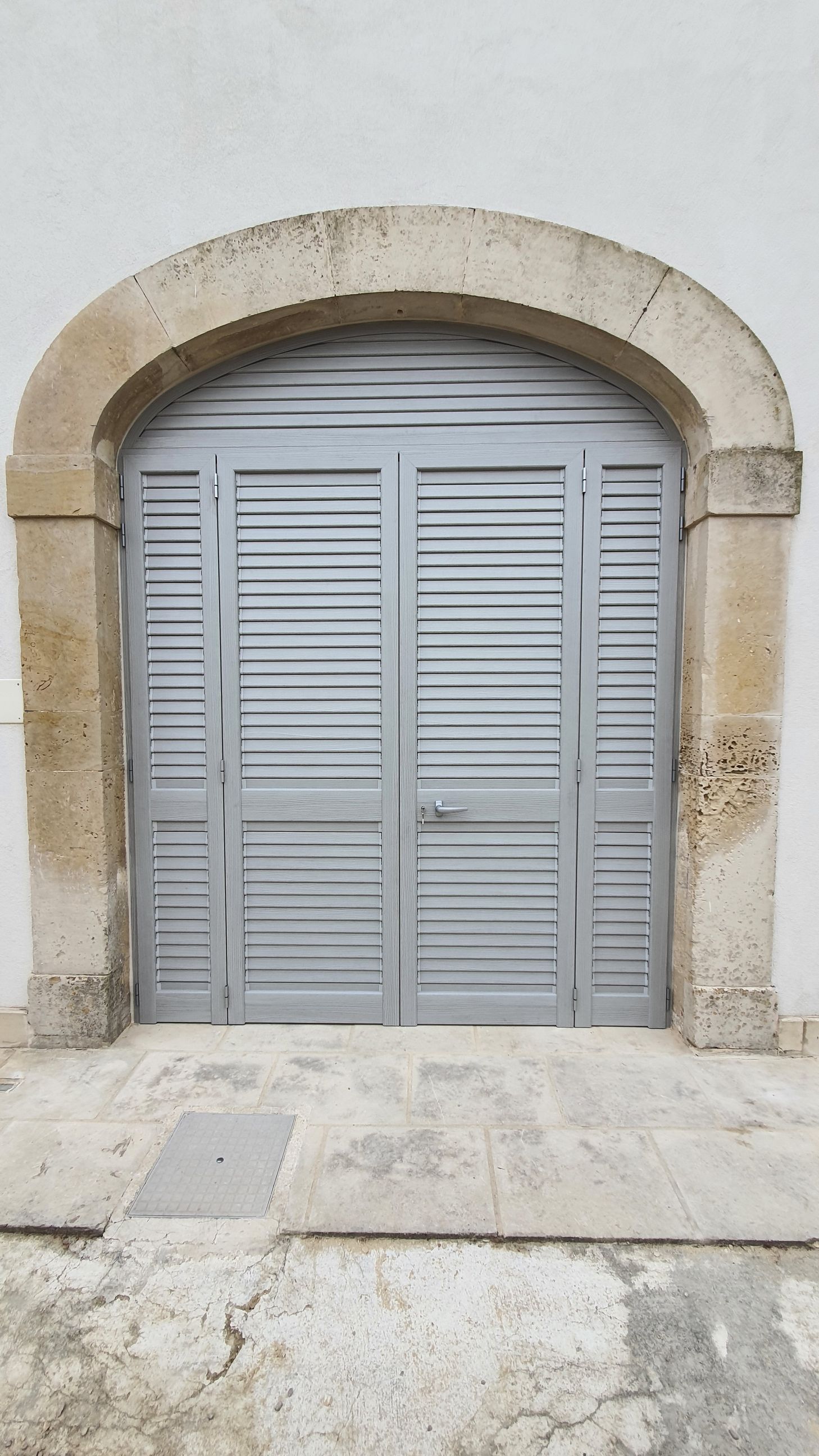 Una porta con le persiane si trova sul lato di un edificio.