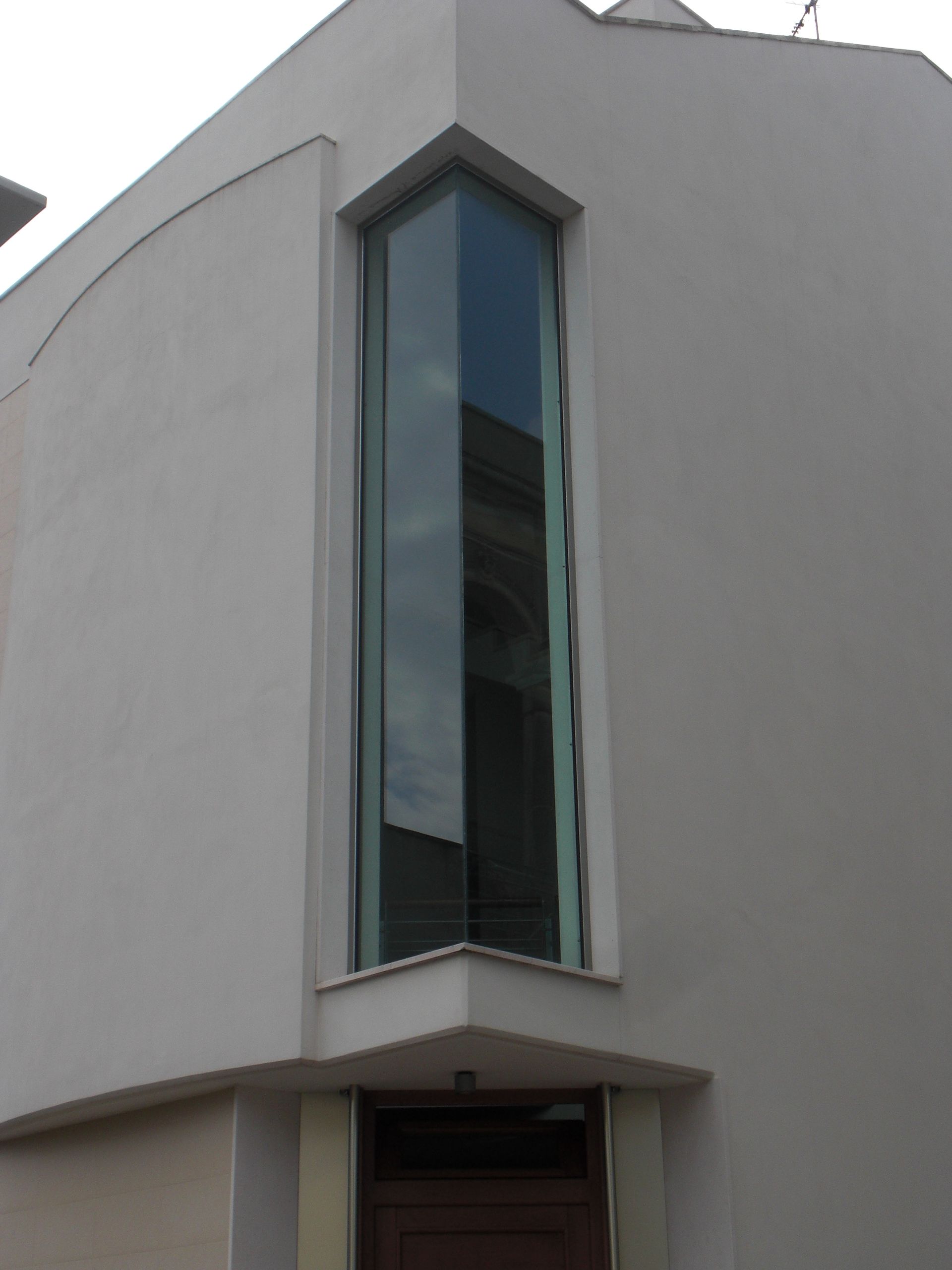 Un edificio bianco con una grande finestra all'angolo