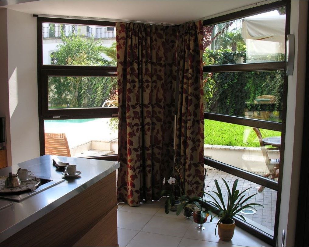 Una stanza con molte finestre e tende