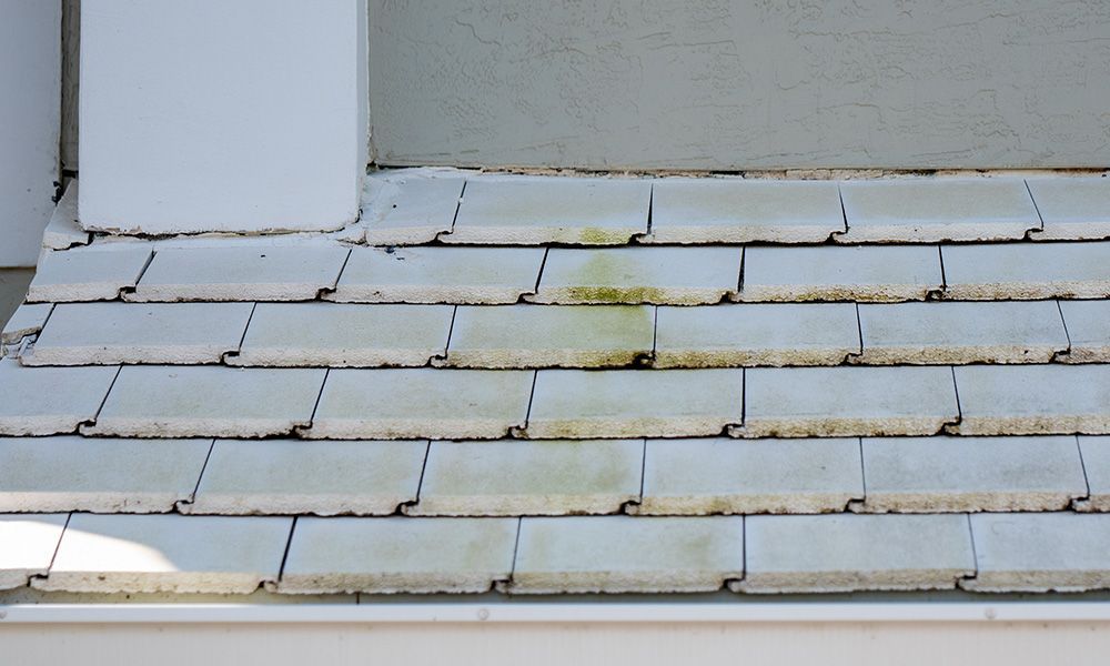 A close up of a roof with white tiles