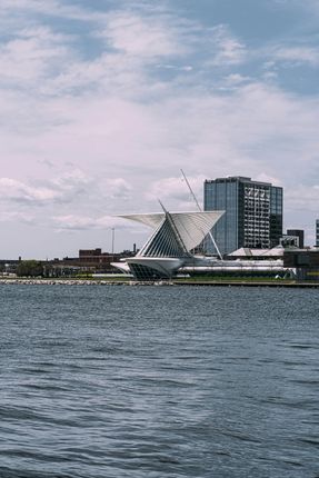 A large building is sitting on top of a body of water.