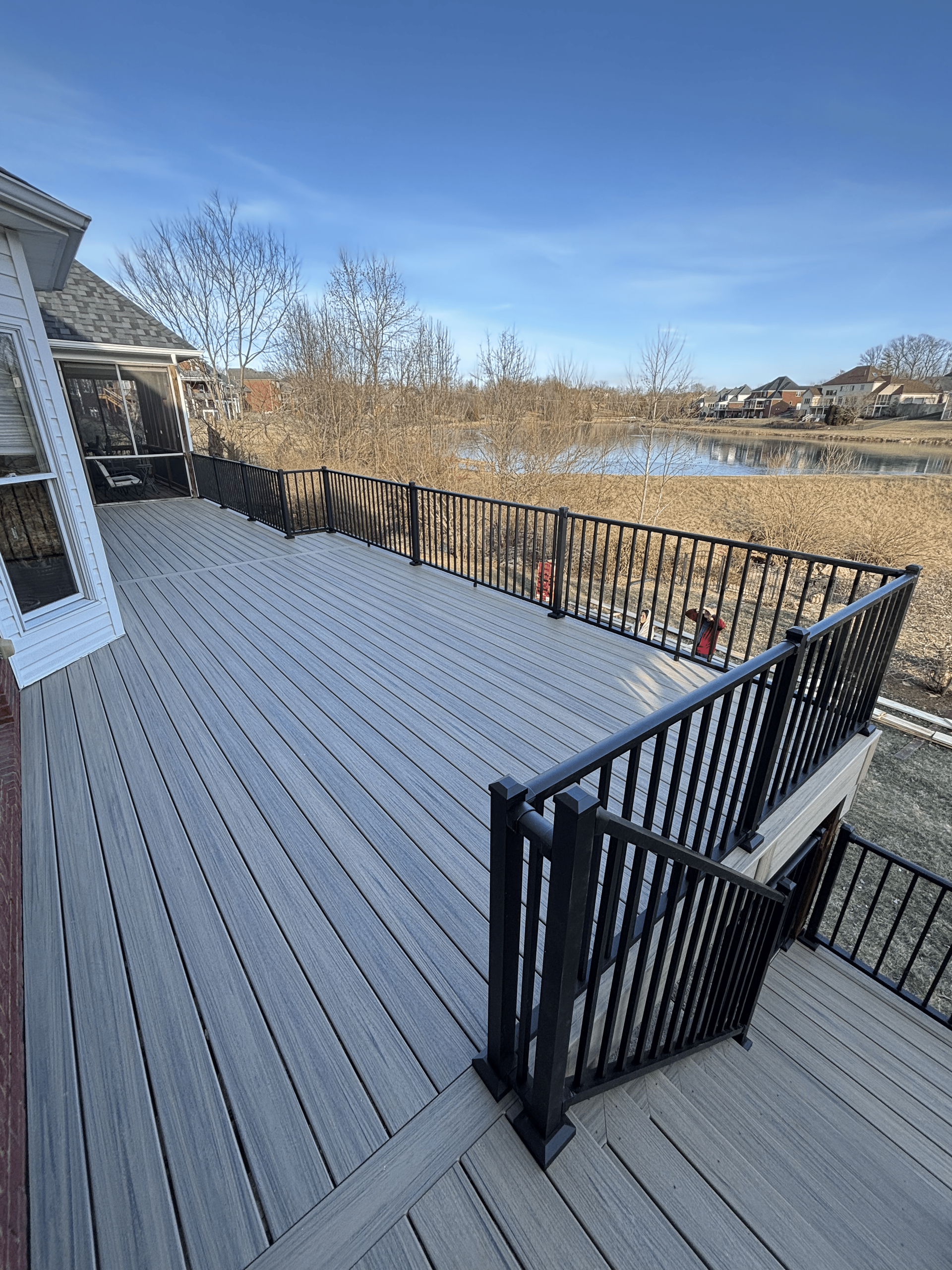Custom backyard wood deck with black metal railing and wooden stairs installed by DeckHeadSky in Murfreesboro