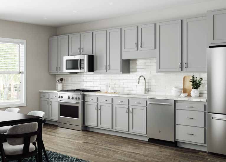 A kitchen with white cabinets , stainless steel appliances , a stove , microwave and refrigerator.