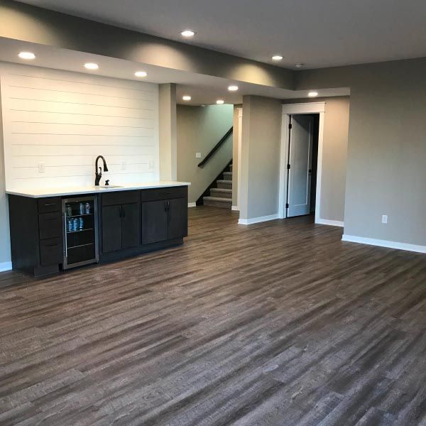 A living room with hardwood floors and a sink