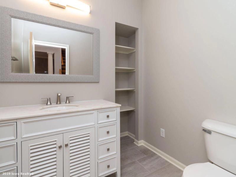 A bathroom with a toilet a sink and a mirror