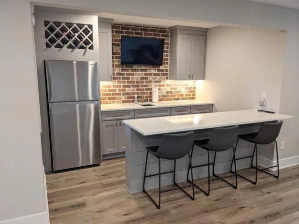 A kitchen with stainless steel appliances and a brick wall.
